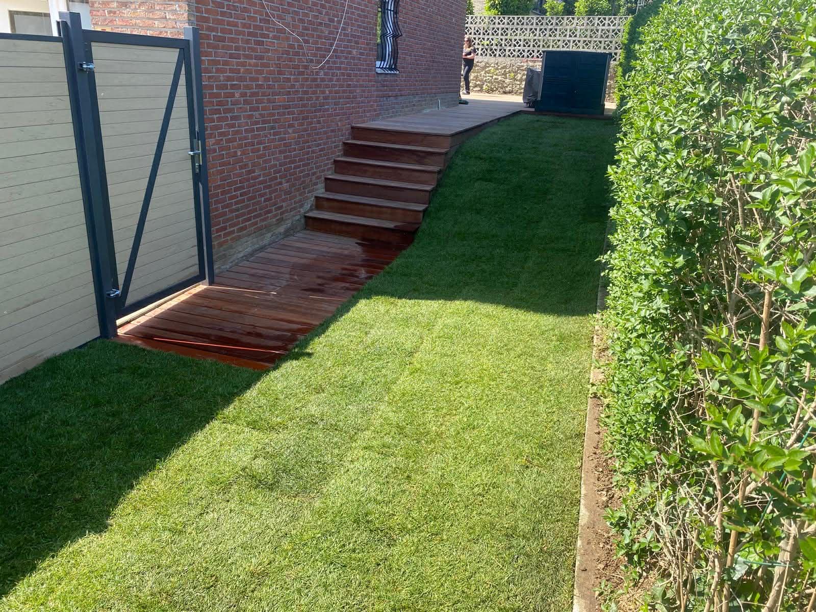 Escalier en bois et pelouse neuve le long d'une haie