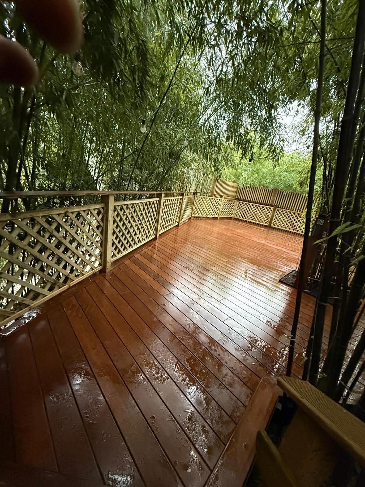 Terrasse en bois exotique avec garde-corps en treillis, entourée de bambous
