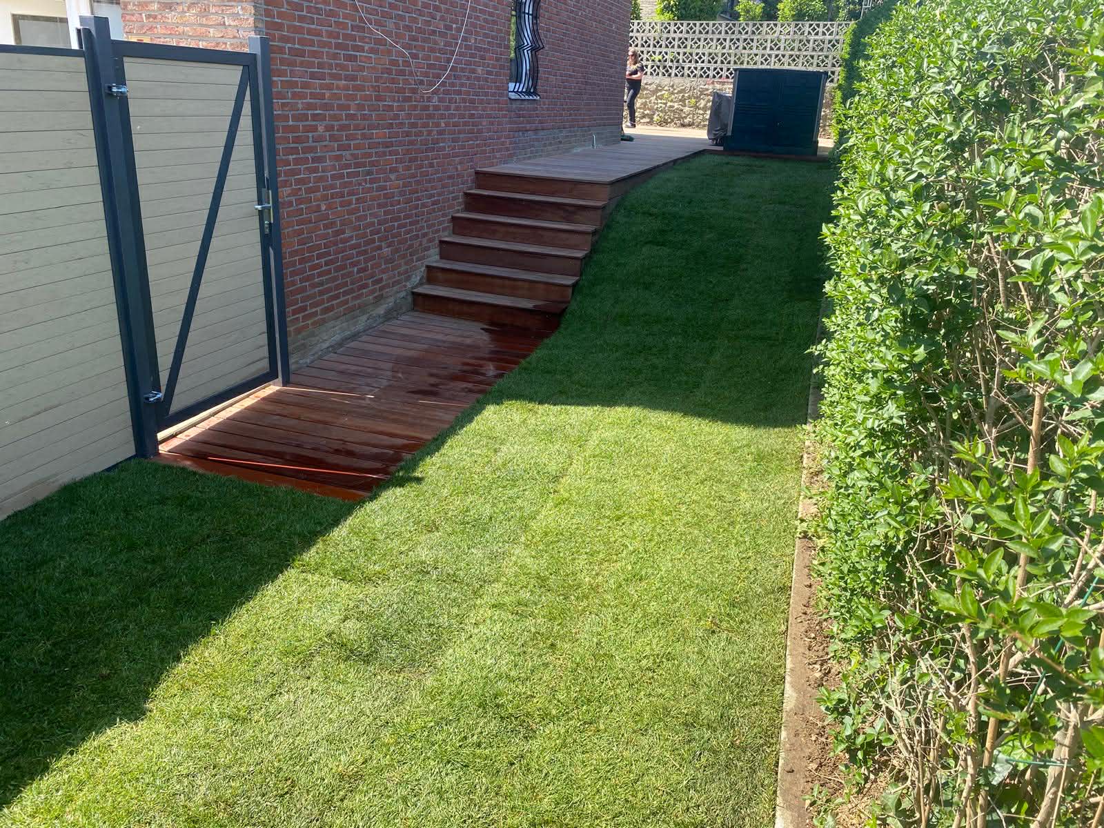 Escalier en bois et pelouse neuve le long d'une haie